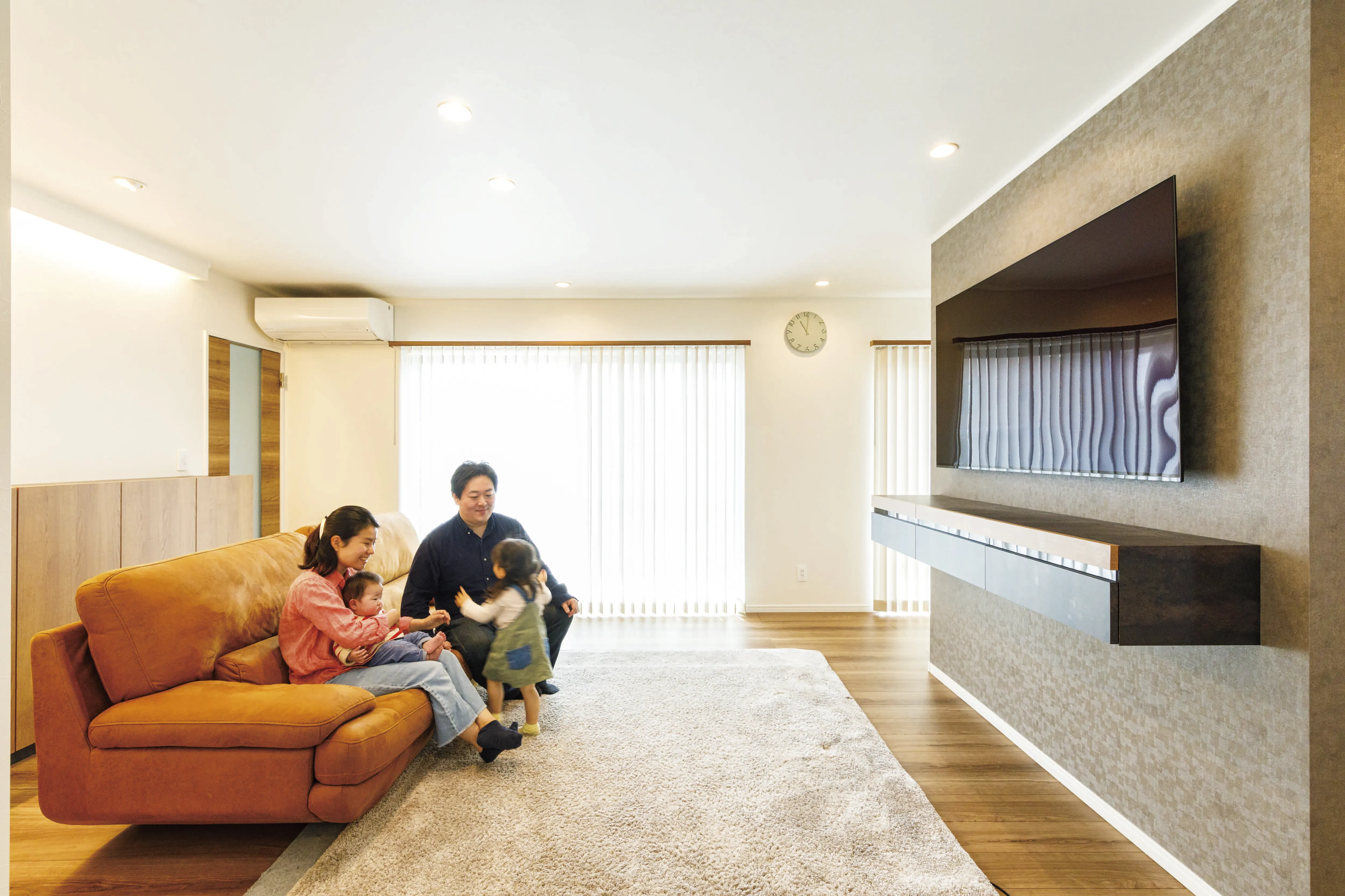 明るいリビングでくつろぐ家族と子どもたち